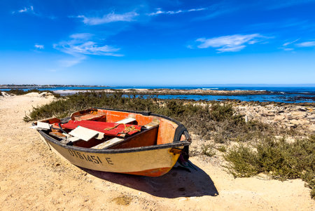 Port Nolloth, South Africa - March 16, 2024: Small fishing rowboat on a beach in coastal townのeditorial素材