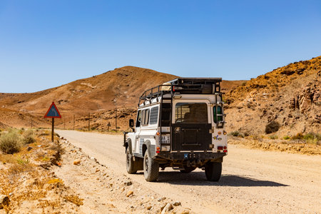 Namaqualand, South Africa - March 11, 2024: Old Land Rover Defender parked on a gravel road in arid...