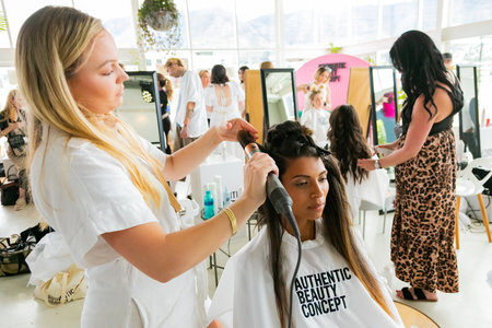 Cape Town, South Africa - November 15, 2022: Professional stylist working on young female model in...