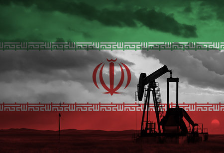 Drilling for oil in the countryside at sunset with Iran national flag overlayの写真素材