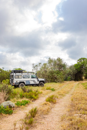 Swellendam, South Africa - October 11, 2025: Old Land Rover Defender parked beside a gravel roadのeditorial素材