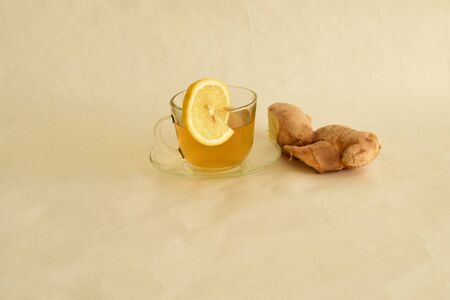 green tea drink, ginger root, lemon, mug of tea on the saucer, transparent glass, interpolation