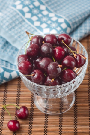 Cherries on glass bowl, blue napkinの写真素材