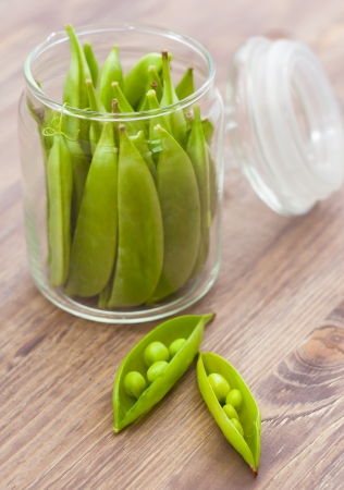 Pea pods in glass jar, wooden backgroundの写真素材