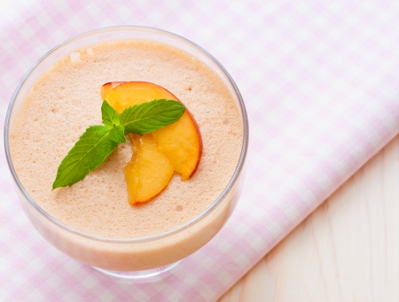 Delicious peach mousse in glass on servietteの写真素材