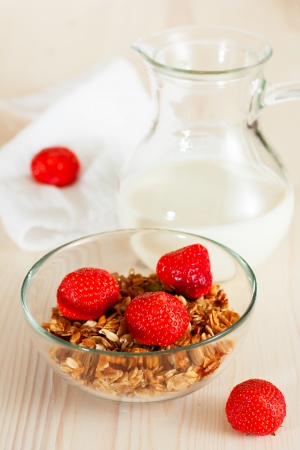 Granola with milk and strawberries, wooden backgroundの写真素材