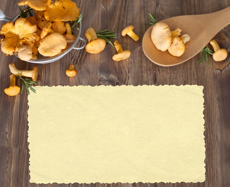 Chanterelles in sieve on wooden background. Space for your textの写真素材