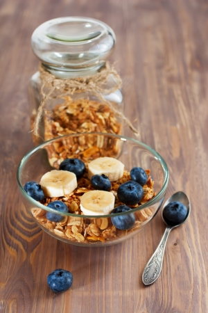 Granola with banana and blueberry in glass bowlの写真素材