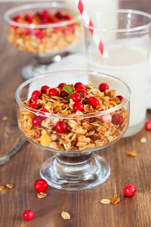 Granola with red berries, wooden backgroundの写真素材