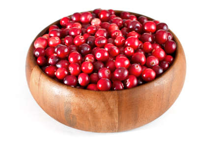 Ripe cranberry in wooden bowl, isolated backgroundの写真素材