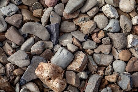 Pile of round  stones by a dried river bankの写真素材