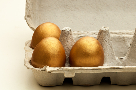 Hand painted golded eggs in an egg cartonの写真素材