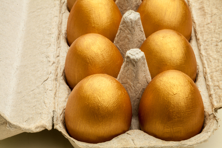 Hand painted golded eggs in an egg cartonの写真素材