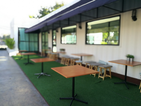 Table outside the restaurant on artificial grass backgroundの写真素材