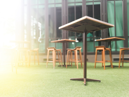 Blurred wood table and chair table on artificial green grass backgroundの写真素材