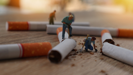Miniature stop smoking concept, Group of miniature mini figures with destroy cigarettes on wooden table backgroundの写真素材