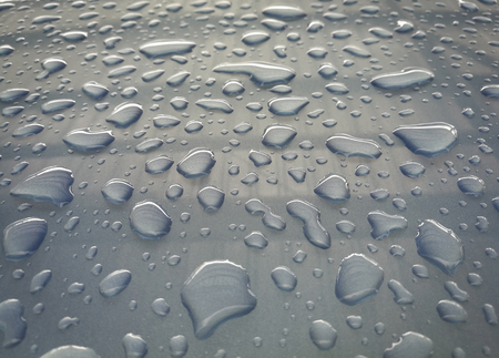 Water drop  of rain on a blue car backgroundの写真素材