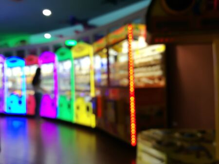 blurred place for play a game child in department store. Playground with colorful neon light and bokeh lightの写真素材