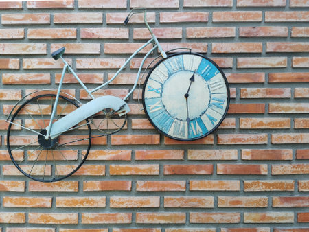 classic bike parked by brick wall, with clock in wheelの写真素材
