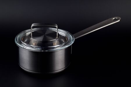 Kitchen pot with a glass lid on a black backgroundの写真素材