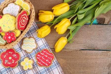 Homemade baked gingerbread and tulips on vintage wooden tableの写真素材