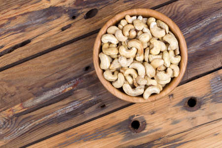 Raw cashews close-up in bowl on a wooden table. Top viewの写真素材