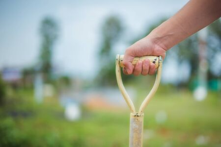 Selective focus man with shovel digging garden bed or farm.の写真素材