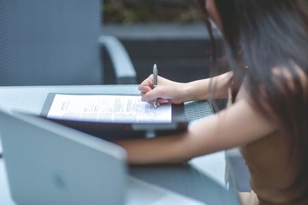Female hand signing contract, Human hands working with documents at the desk closeup, Two business partners signing a document, Selective focus.の写真素材