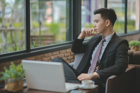 Young attractive Asian business woman sleeping, drowsing or taking a nap at her desk, Tired business woman accountant with bills and paper folders in office, tired young business woman with laptop.の写真素材