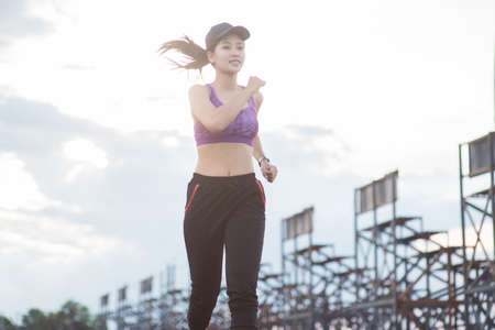Young woman runner is jogging on the street be running for exercise.の写真素材