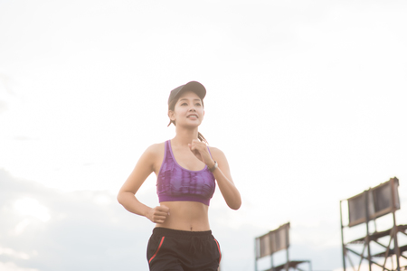 Young woman runner is jogging on the street be running for exercise.の写真素材