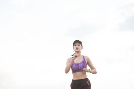 Young woman runner is jogging on the street be running for exercise.