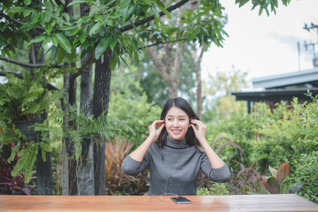 Portrait of young businesswoman use mobile phone while sitting in comfortable coffee shop during work break, charming happy female reading fashion news on cell telephoneの写真素材