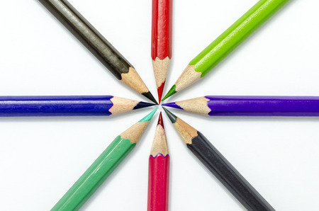 Color pencils in arrange in color wheel colors on white paper background