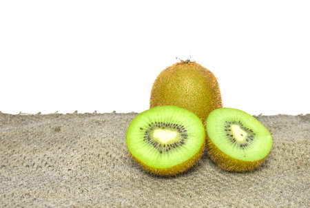 Ripe whole kiwi fruit and half kiwi fruit isolated put on brown sackの写真素材