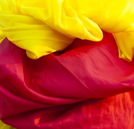 Shine red and yellow pearl fabric silk or satin luxury cloth texture. Smooth elegant chiffon backgroundの写真素材
