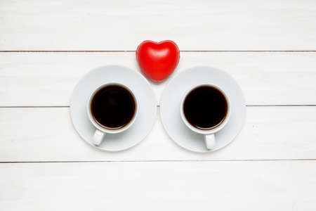 Cup coffee or black tea with red heart top view on white plank wooden background