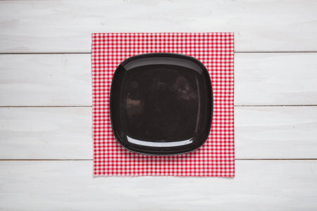 Empty Plate with textile napkin on plank white wood background. Top view. Copy space. Montage product.の写真素材