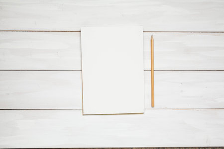 Open book or note and pencil on wooden white plank background. Top view with copy space.の写真素材