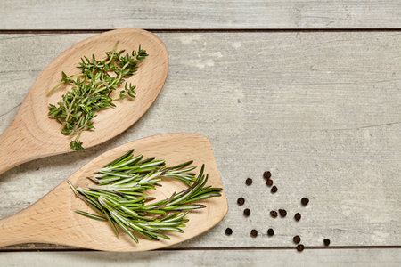 Wooden spoon with Caraway and rosemary, onion, garlic on background. Top view.の写真素材