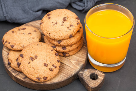 chocolate cookie with orange juice on wooden background, close upの写真素材
