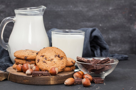 milk and chocolate cookie on wooden black backgroundの写真素材