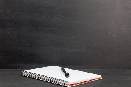pen, notebook on black chalk board with copy spaceの写真素材