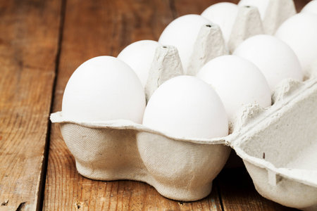White egg, pack on wood table