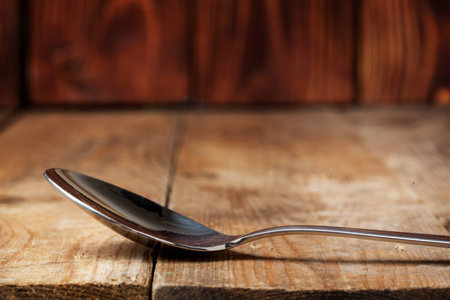 Metal spoon on wooden table with copy space