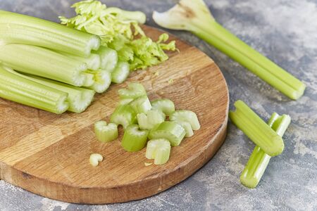 Macro sliced Celery on wooden chopping board. Preparation for cooking.