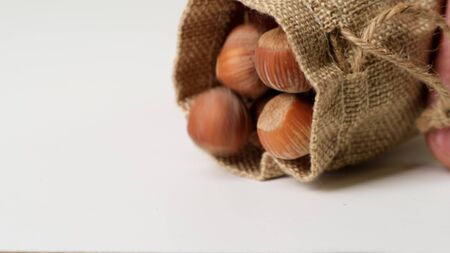 Hazelnut dropping on the white table in slow motion. Close up.