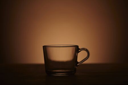 Glass cup of tea brown background. Close up.