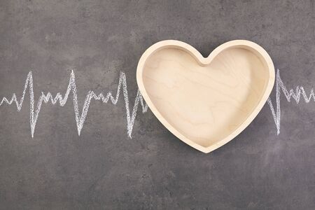 Wooden shaped heart with cardiogram over table. Healthcare conceptの写真素材