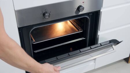 Opening Oven in kitchen witk light. Close up.